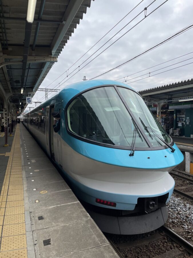 <!-- アイキャッチ画像：naiku-2.jpg（早朝の宇治橋鳥居） -->

# 伊勢神宮、泊まりで行くとこんなにちがった。60代のちいさな贅沢旅

伊勢神宮に何度か参拝してきた。いつも車で、日帰りで。それが今年、はじめて一泊することにした。

変えたのはそれだけ。なのに、旅がまるごと別物になった。

電車で行って、鰻を食べて、内宮の前に泊まって、早朝の参道を歩く。そんな旅が、伊勢ではできる。


## 電車で行くと、旅がらくになる

<!-- 写真：isesimaraina-0.jpg（ホームに停まる伊勢志摩ライナー） -->

大阪難波から伊勢志摩ライナーのデラックスカーで、2時間かからずに伊勢市に着く。

特急料金に360円ほど上乗せするだけで、座席まわりがぐっと変わる。隣席とは固定のひじ掛けで仕切られていて、自分だけの空間がある。渋滞も、駐車場探しも、運転疲れもない。伊勢に着いたとき、体力がまだ残っている。

<!-- 写真：isesimaraina-2.jpg（デラックスシートの座席） -->

車だとどうしても駐車場を起点に動くことになるが、電車だと駅から歩いて自由に動ける。これがおもしろい。気になったところに立ち寄れるし、歩きながら町の空気を感じられる。

<!-- 写真：isesimaraina-1.jpg（車窓と本） -->

ひとつ小さな工夫を。6号車の奇数席（7Bや7Cなど）は窓枠のない席で、車窓の景色がさえぎられずに広がる。事前予約のときに選んでみると、移動がすこし楽しくなる。


## 伊勢に着いたら、まず鰻を食べてほしい

<!-- 写真：unagi.jpg（鰻丼と白焼きのセット） -->

伊勢市駅から歩いてすぐのところに、鰻の卸をやっているお店がある。「はじめ」という店で、もともとテイクアウト専門だったらしく店内はシンプル。観光地らしい華やかさはないけれど、鰻はほんものだった。

鰻丼と白焼きのセットで3,400円。白焼きが格別だった。タレをつけずにそのまま食べる鰻は、皮がパリッと、身はふっくら、臭みがまったくない。「鰻ってこんな味だったのか」と思うような一皿だった。

腹ごしらえをしてから、のんびり外宮へ。時間を気にせず参道を歩いて、ゆっくり手を合わせる。急がなくていい、というのがこんなに気持ちいいとは思っていなかった。


## 内宮の目の前に泊まれる宿がある

<!-- 写真：jingukaikan.jpg（神宮会館の石碑） -->

神宮会館は、伊勢内宮のすぐ目の前にある。この立地がすごい。

チェックインして荷物を置いたら、身軽になっておかげ横丁へ。

<!-- 写真：okage-2.jpg（青空のおかげ横丁） -->

赤福の茶屋でぜんざいをひとつ食べて、お土産の赤福餅を買って、おかげ横丁のカフェでコーヒーを飲む。歩いて全部できてしまう。

<!-- 写真：okage-1_jpg.jpg（ぜんざい） -->

一泊二食付きで16,500円（税・サービス料込み）。部屋はシンプルで、食事もふつう。でもスタッフがみな笑顔で、居心地がいい。一人で宿泊している人も多く、ひとり旅でもまったく気兼ねがない。

ひとつだけ言っておくと、予約はなかなか取れない。行くと決めたら早めに動いたほうがいい。


## 砂利を踏む音だけが聞こえる朝

<!-- 写真：asayake.jpg（朝焼けの空） -->

これが、この旅のいちばんよかったことだった。

神宮会館には、無料の早朝参拝ガイドツアーというオプションがある。翌朝6時半に集合して、ガイドと一緒に内宮へ向かう。

<!-- 写真：naiku-2.jpg（早朝の宇治橋鳥居） -->

参道に入ると、静かだった。砂利を踏む音と、鳥の声。それだけしか聞こえない。朝の空気が澄んでいて、歩くたびに気持ちが整っていくような感覚がある。

<!-- 写真：naiku-1.jpg（砂利の参道） -->

ガイドは宿のスタッフだが、地元の人ならではの話が多い。神宮の成り立ち、参拝の作法の意味、ガイドブックには載っていないような話を聞きながら歩く1時間半。無料とは思えない内容だった。

8時半を過ぎると、観光バスが続々と到着して参拝客が増えてくる。その前の静かな時間帯に歩けることが、泊まりでしかできない特権だと思う。

---

電車で行って、歩いて、食べて、泊まって、早朝に参拝する。

伊勢神宮でこんな旅ができる。60代になって時間の使い方が変わってきたなと感じているなら、一度こういう旅をしてみてほしい。一人でも、十分に楽しめる。